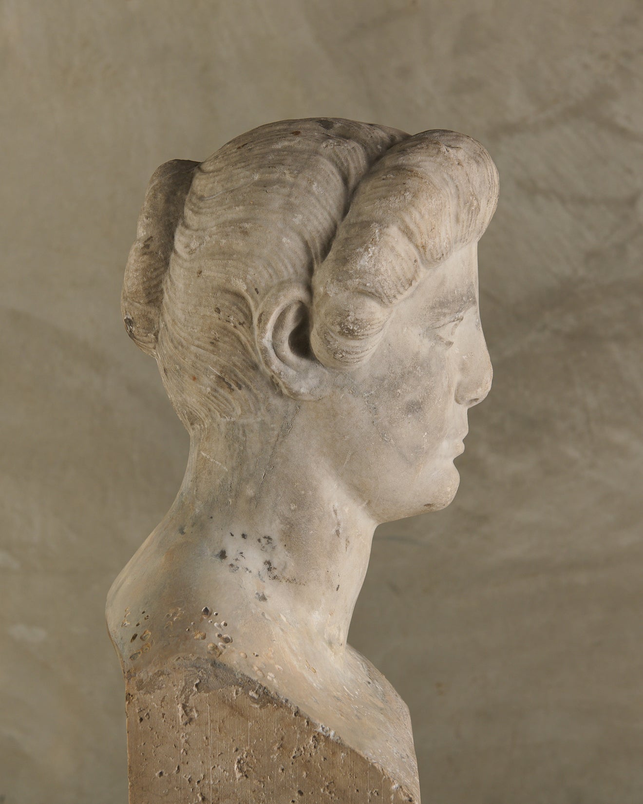 LIMESTONE PORTRAIT HEAD OF A WOMAN RESEMBLING CLEOPATRA VII ON TRAVERTINE PLINTH