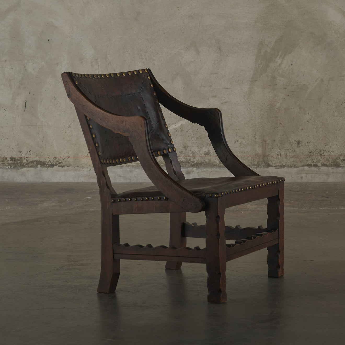 SPANISH COLONIAL LEATHER STUDDED LOW ARM CHAIR