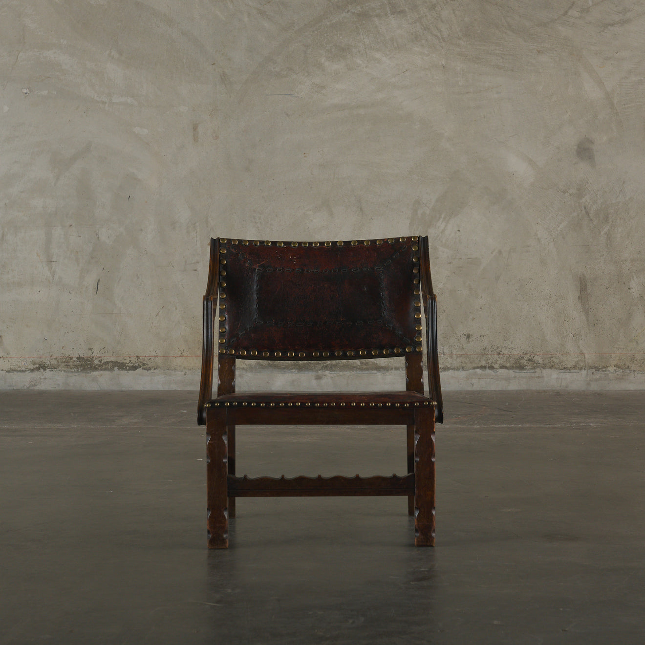 SPANISH COLONIAL LEATHER STUDDED LOW ARM CHAIR