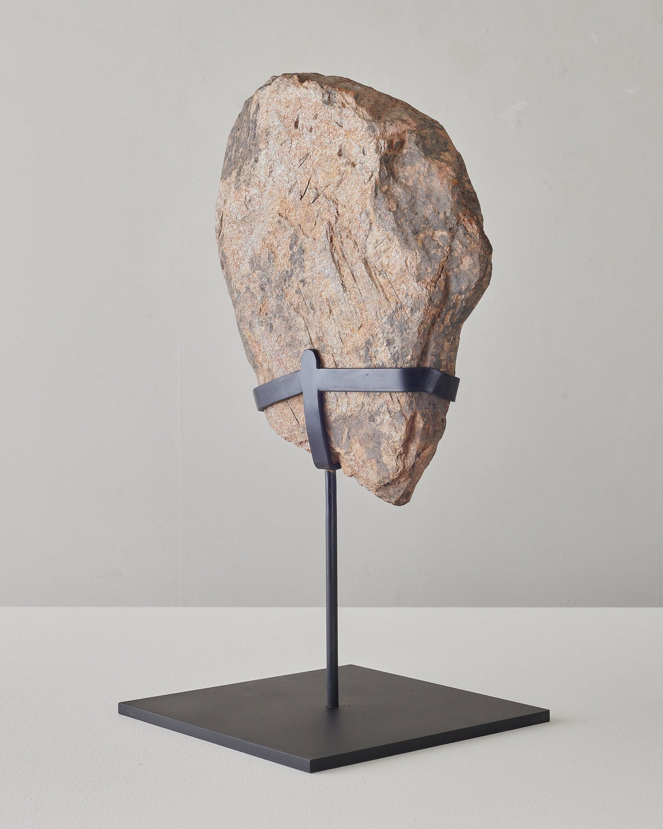 Carved relief stone face on stand