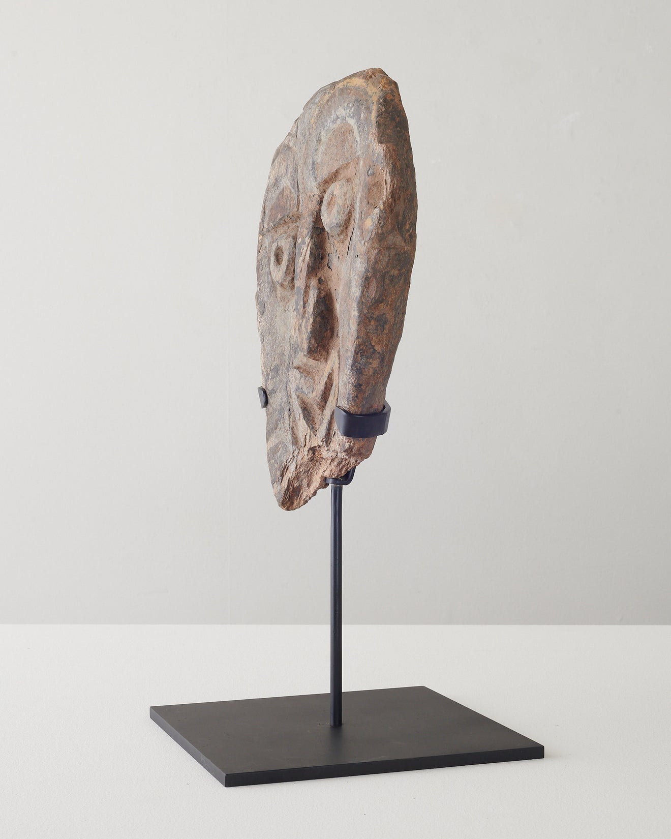 Carved relief stone face on stand