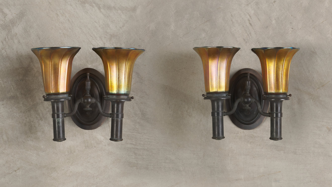 PAIR OF BRONZE SCONCES IN THE MANNER OF TIFFANY STUDIOS WITH STEUBEN SHADES, 20th C
