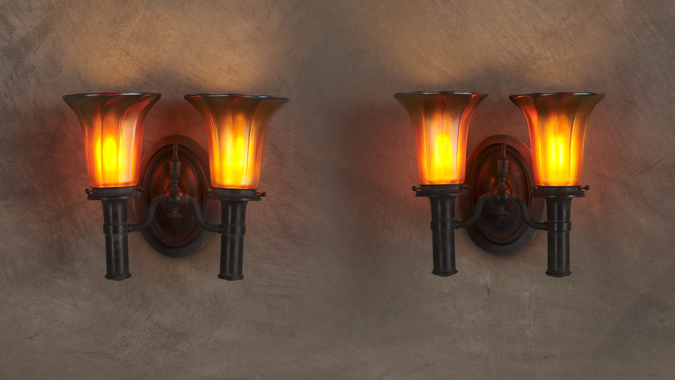 PAIR OF BRONZE SCONCES IN THE MANNER OF TIFFANY STUDIOS WITH STEUBEN SHADES, 20th C