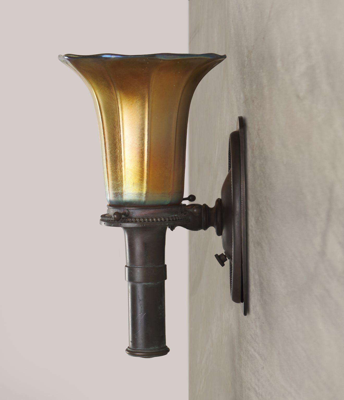 PAIR OF BRONZE SCONCES IN THE MANNER OF TIFFANY STUDIOS WITH STEUBEN SHADES, 20th C