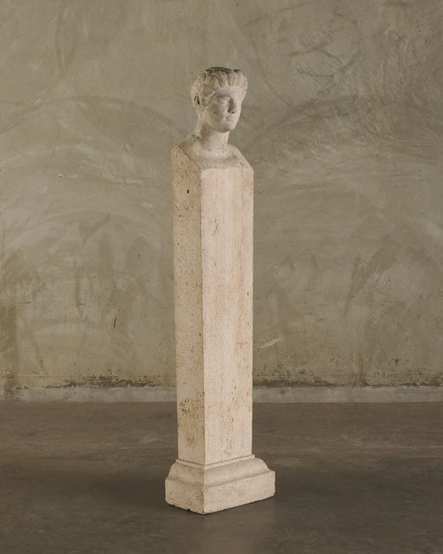 LIMESTONE PORTRAIT HEAD OF A WOMAN RESEMBLING CLEOPATRA VII ON TRAVERTINE PLINTH