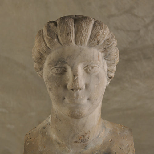 LIMESTONE PORTRAIT HEAD OF A WOMAN RESEMBLING CLEOPATRA VII ON TRAVERTINE PLINTH