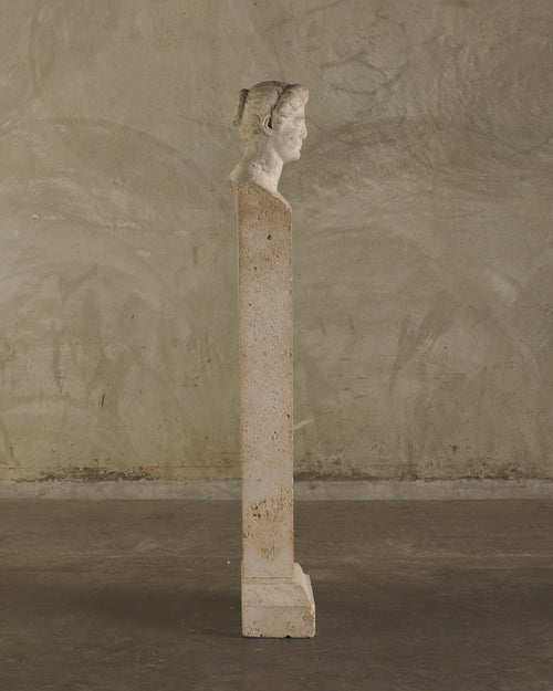 LIMESTONE PORTRAIT HEAD OF A WOMAN RESEMBLING CLEOPATRA VII ON TRAVERTINE PLINTH