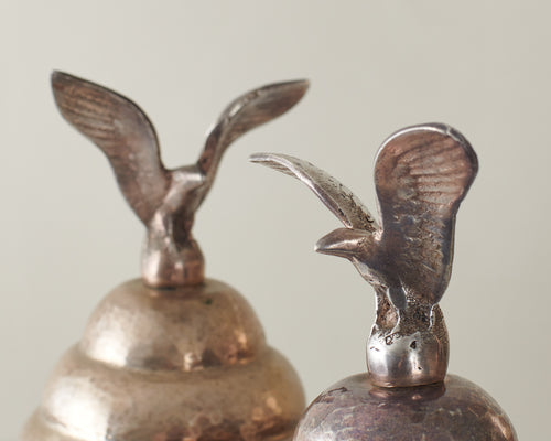 PAIR OF EAGLE TOP SILVER BEATEN METAL URNS